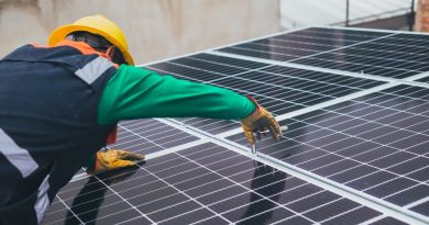 Profesional con casco revisa la colocación de paneles fotovoltaicos; imagen ilustrativa de obra no identificada