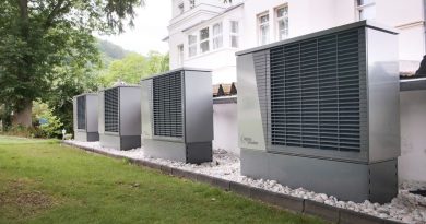 Varias unidades exteriores de bomba de calor junto a un edificio; imagen ilustrativa sin relación con una vivienda catalana específica