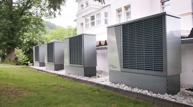Varias unidades exteriores de bomba de calor junto a un edificio; imagen ilustrativa sin relación con una vivienda catalana específica