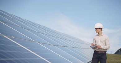 Persona con casco revisa paneles solares en instalación en suelo; imagen ilustrativa, no una cubierta catalana